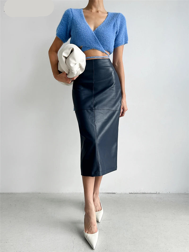 Model posing with the skirt and a statement handbag for an elevated look