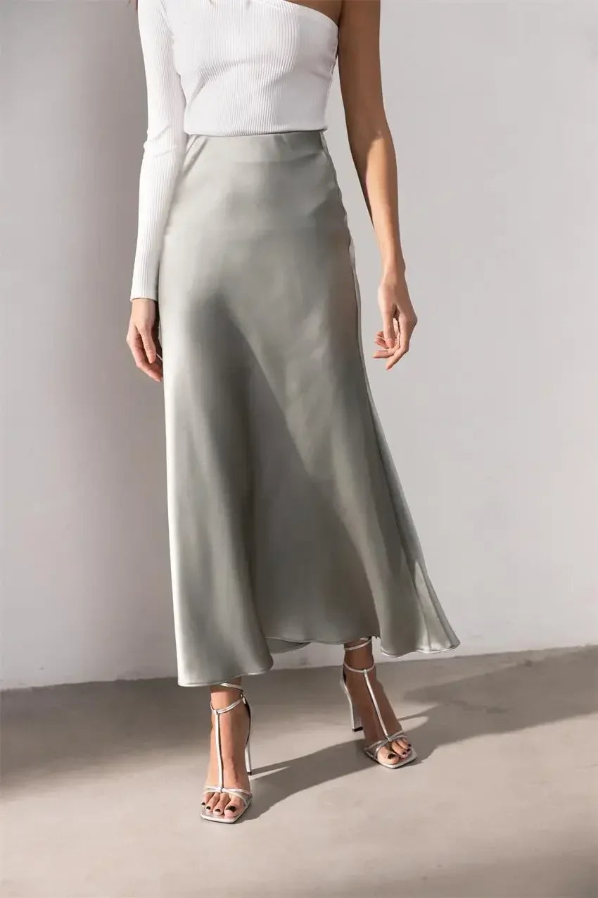 Women's flowy skirt styled with heels and a blouse.