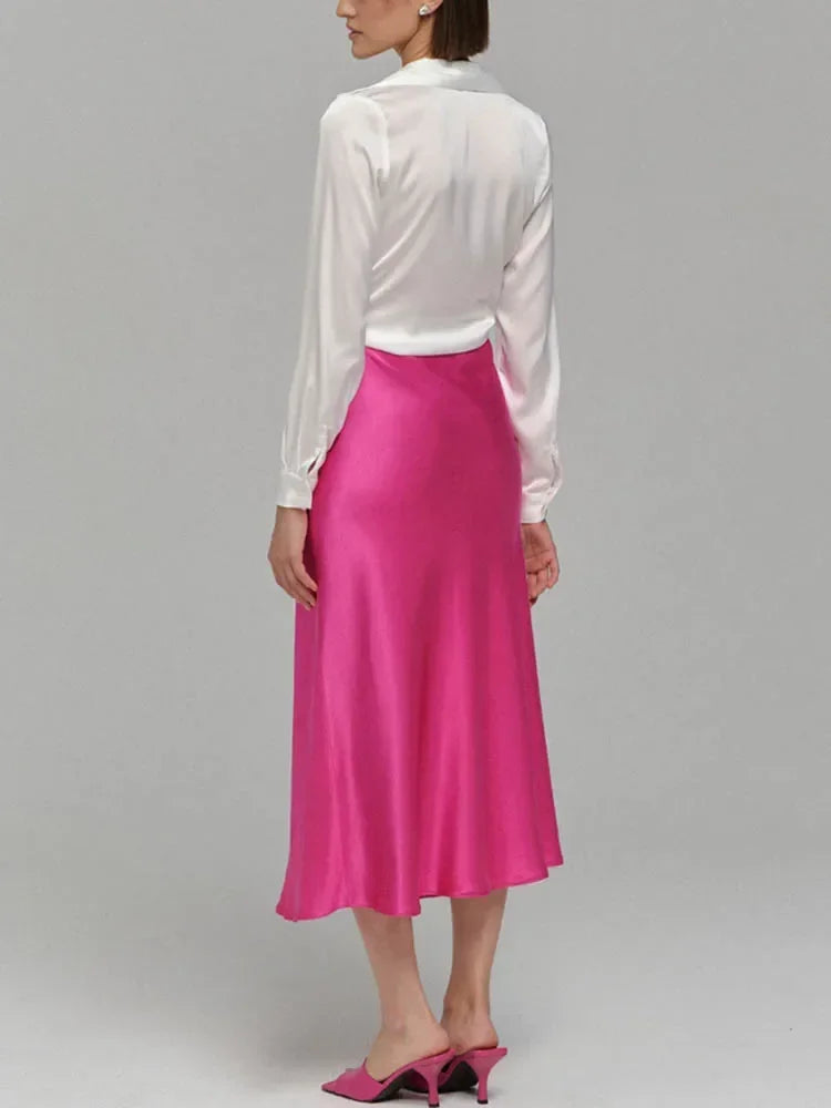 A-line skirt styled with a tucked-in shirt and sneakers.