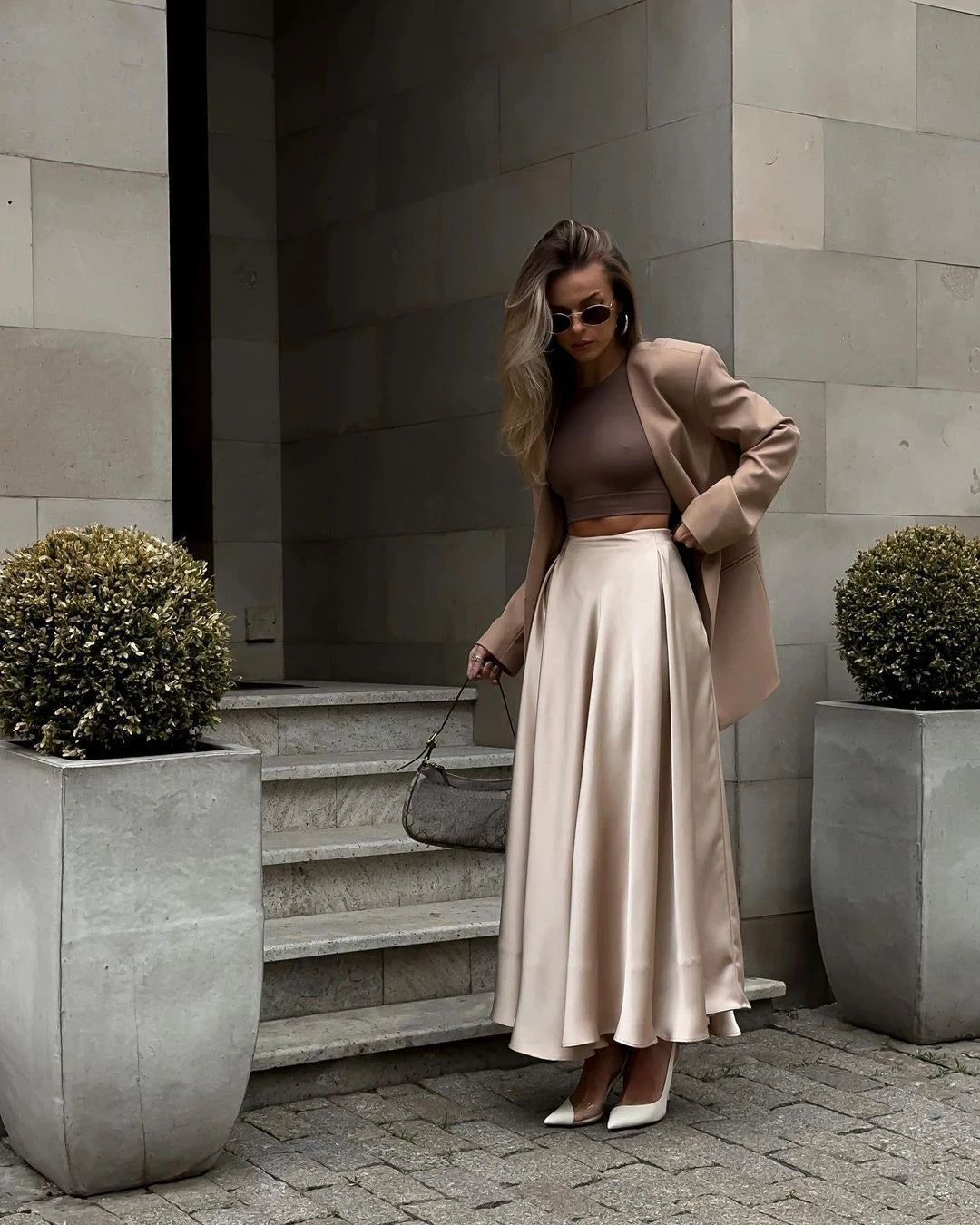 Model twirling in an ankle-length satin skirt.