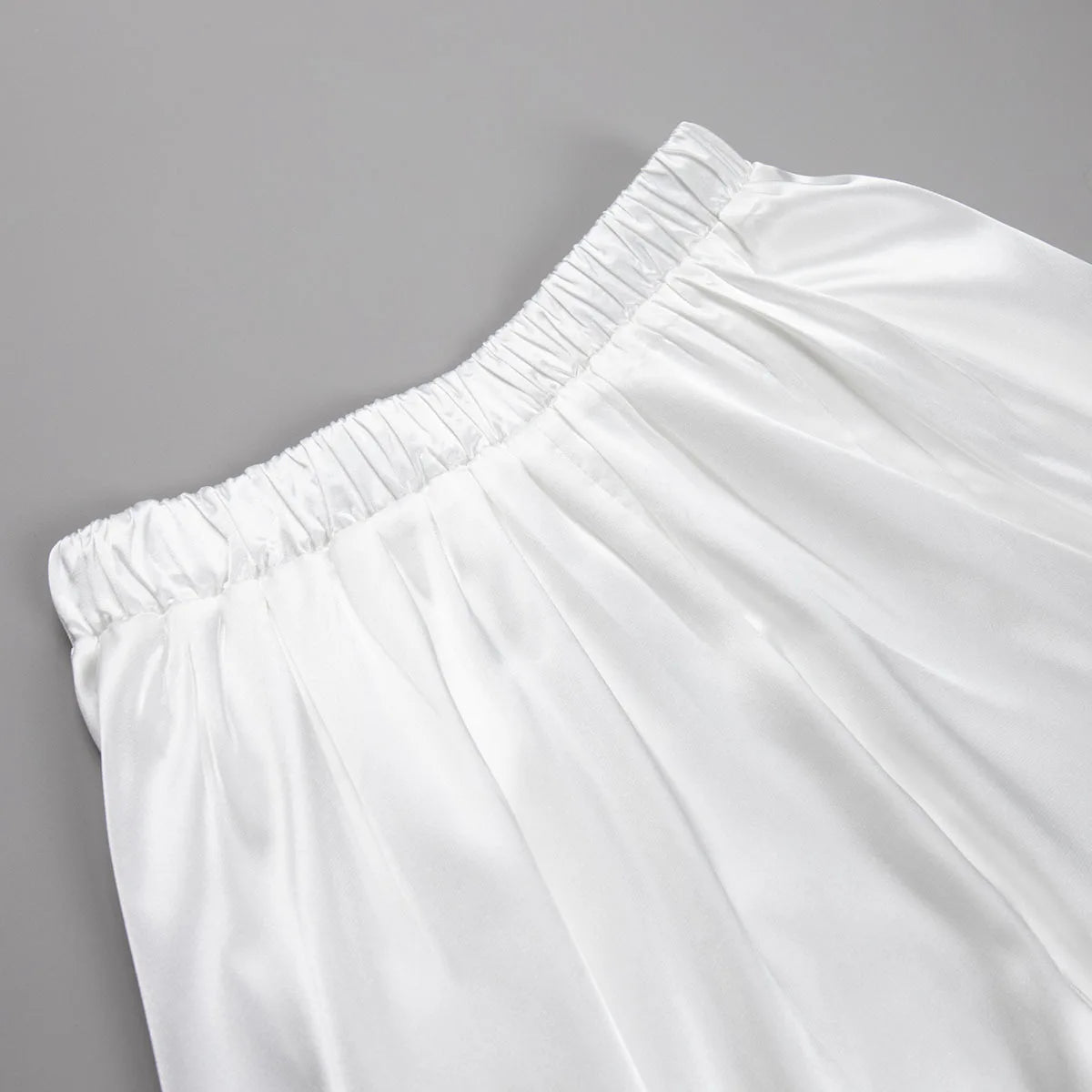 Satin skirt displayed on a clothing rack with autumn-themed accessories.