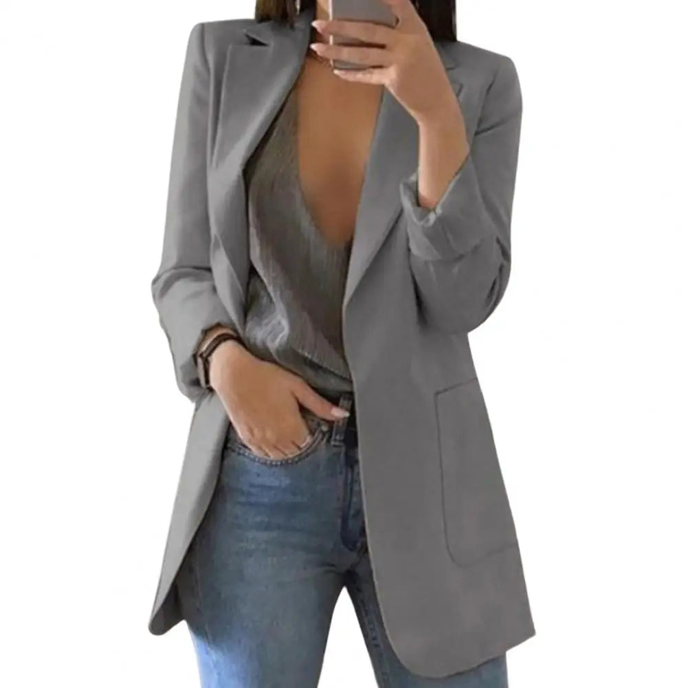 Side profile of a woman wearing a fitted long sleeve blazer for autumn.