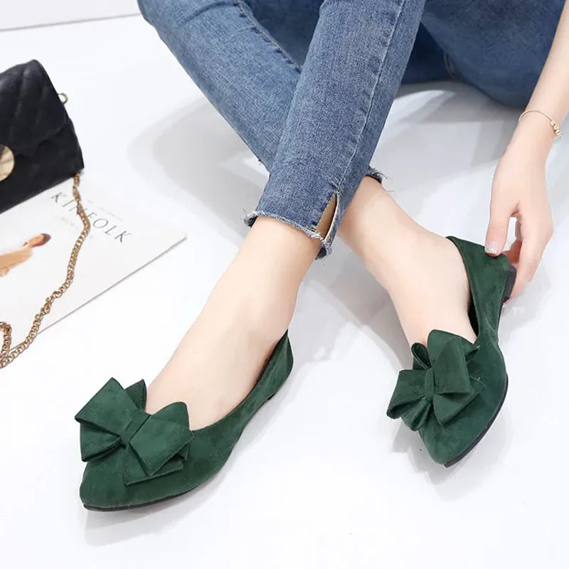 Pair of Green Bow Tie Flock Flat Shoes on a white background.