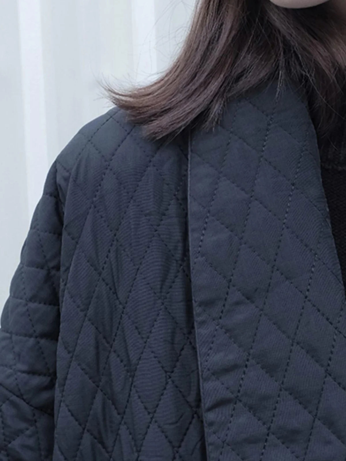 Close-up of the V-neck detail of the casual cotton coat.