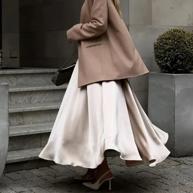 Ankle-length satin skirt paired with a sweater and boots.
