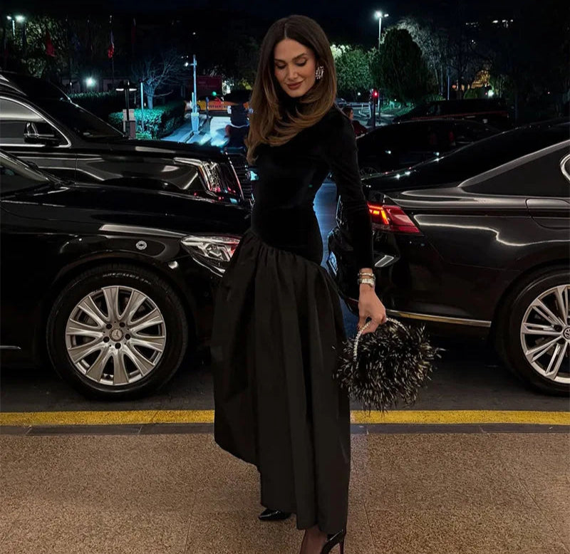 Model posing in a black pleated satin maxi dress
