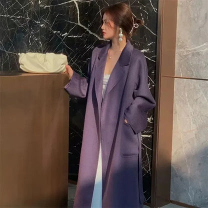 Elegant woman layering a ripple wool coat over a dress.