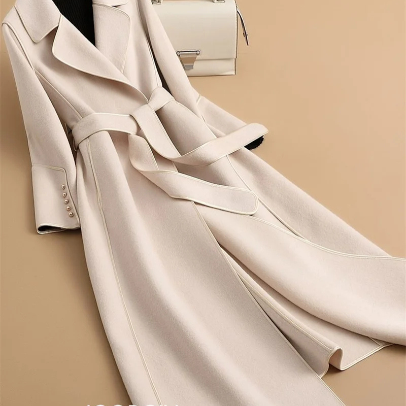 Woman closing the buttons of the Elegant White Double-Sided Cashmere Coat.
